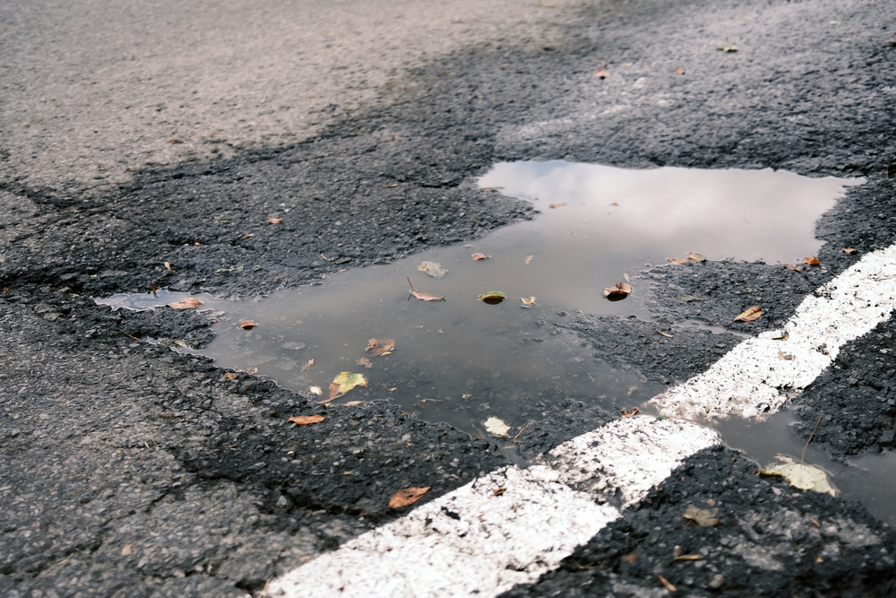 Pothole,On,The,Asphalt,Road,With,Potholes,And,Cracks.